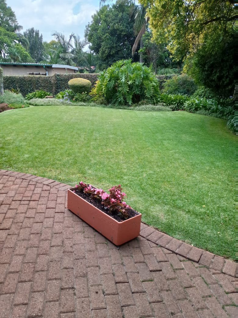 A brick garden path running alongside a well-kept lawn